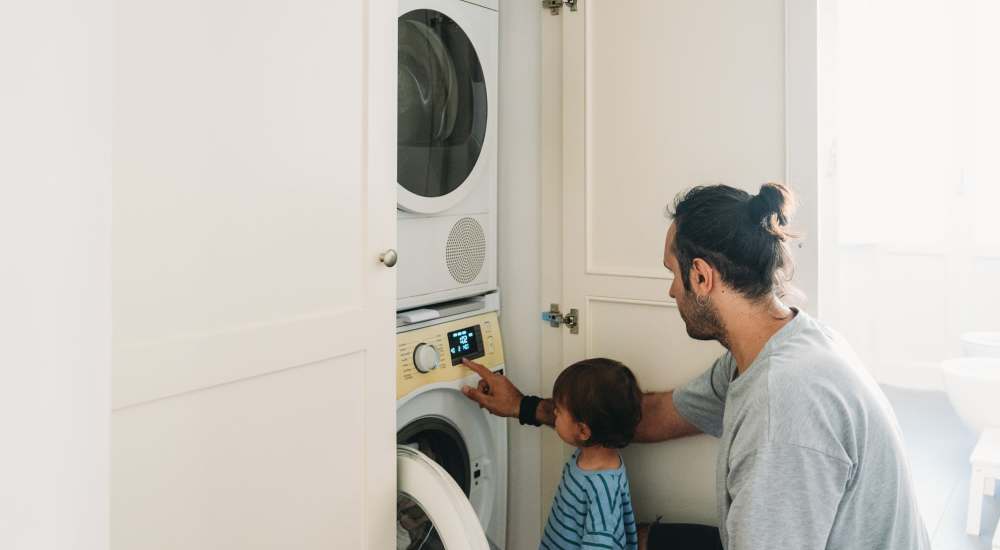 Father and toddler using laundry machine at NorthPark Apartment Homes in Gainesville, Texas 