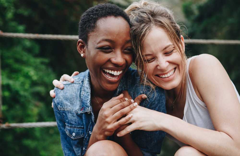 Two friends enjoying a joyful moment together at Northside Manor Apartments in Rochester, New York 