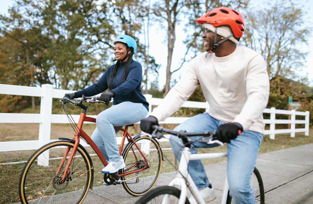 Couple biking outdoors, enjoying the fresh air at Northside Manor Apartments in Rochester, New York