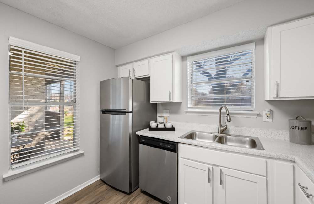 Stainless-steel refrigerator, dishwasher and white cabinetry in the kitchen at 18Eleven Frankford in Carrollton,Texas