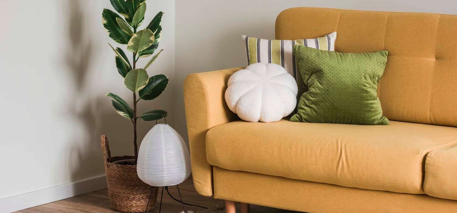 Living area with a couch and lively plant at Grande Oak III in Williamsburg, Virginia