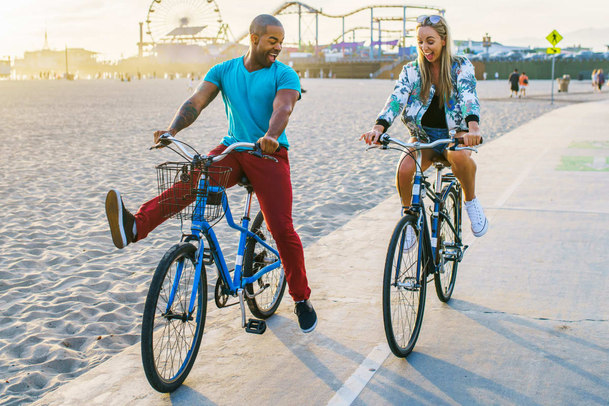 A couple rides bikes at beach near Playa Del Oro, Los Angeles, California