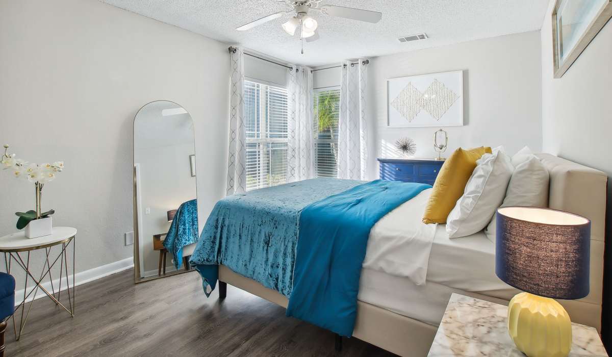 Modern bedroom with ceiling fan and windows at The Canopy Apartment Villas in Orlando, Florida