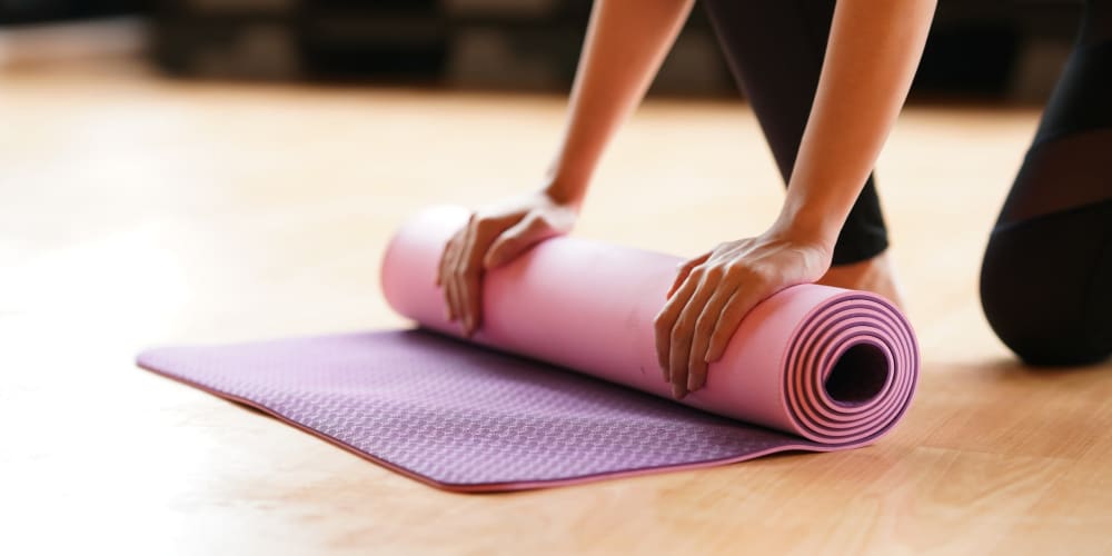 Unrolling a yoga mat in the fitness center at Mosby Bridge Street in Huntsville, Alabama