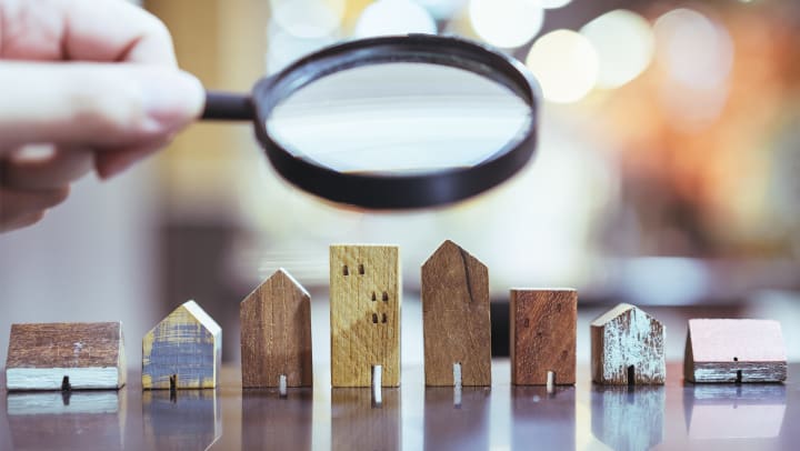 A magnifying glass over toy houses