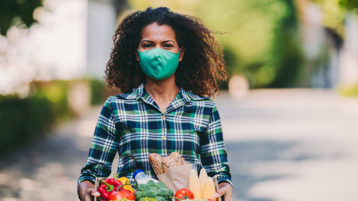 Woman holding a box with fresh vegetables 