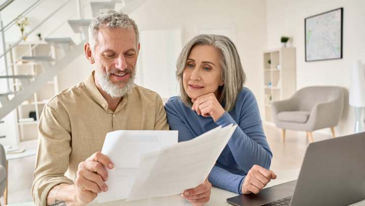 Senior couple in their home looking at documents