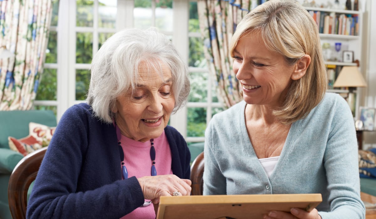 A resident and her daughter looking at a photograph at CERTUS Premier Memory Care Living in Vero Beach, Florida.