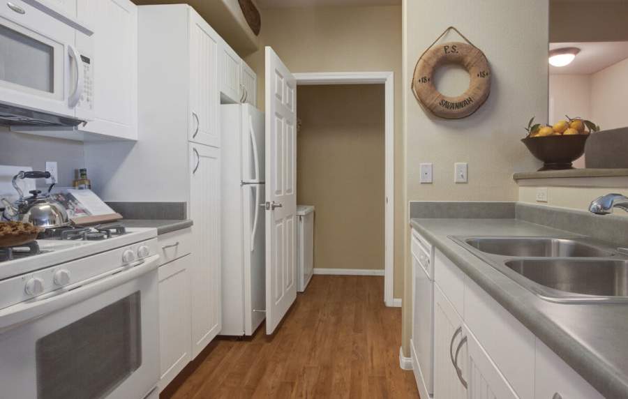 Modern kitchen with white appliances and cupboards at Rivers Edge in Lake Elsinore, California