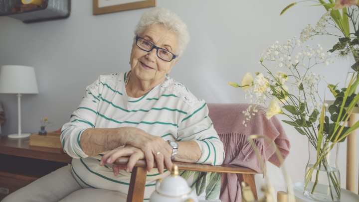 Elderly woman sitting on a chair and smiling