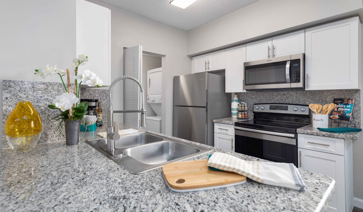 Modern apartment kitchen with and granite counters and stainless-steel appliances at Nova Central Apartments in Davie, Florida