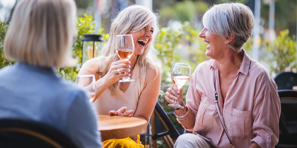 Residents having wine and laughing at Villas of Juno Apartments in Juno Beach, Florida