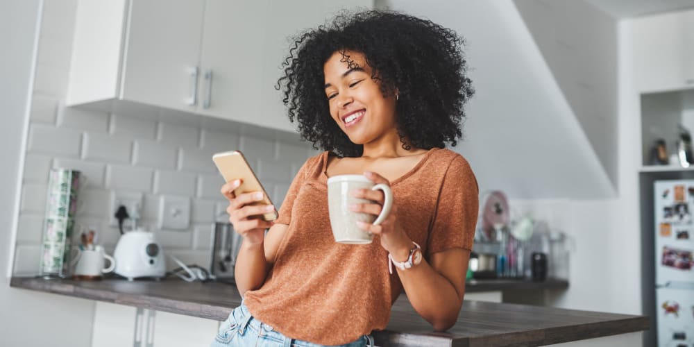 A resident looking at her phone in her kitchen at Vesta Bouldercrest in Atlanta, Georgia