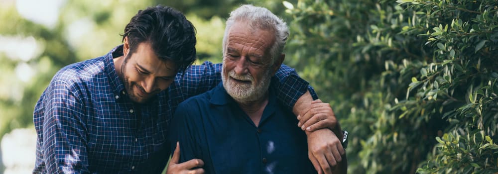 A staff member walking with a resident at a Stoney Brook community