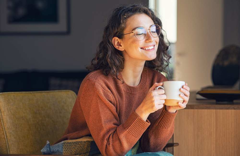 Resident smiling with a warm cup of tea in her new home at East Ridge Village in East Ridge, Tennessee