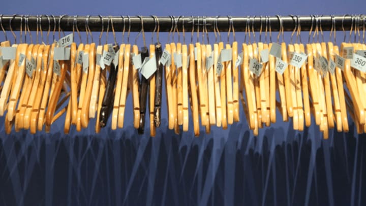 Multiple hangers, with tags, hanging from a rack | Unsplash