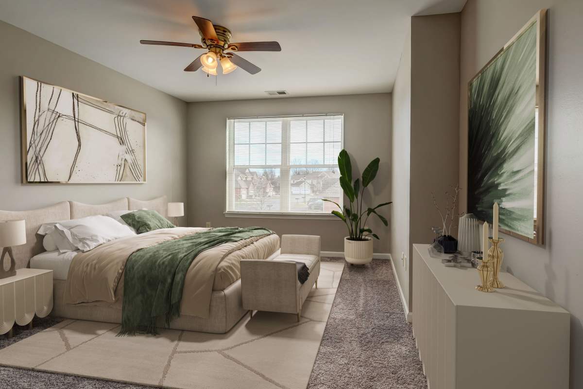Staged bedroom with large windows, a ceiling fan, and wall to wall carpet