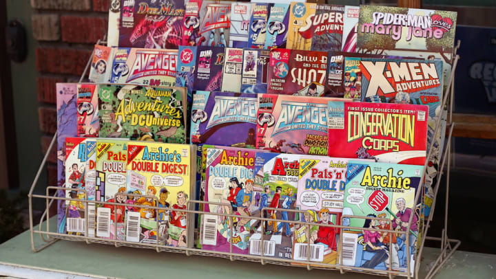 An assortment of popular comic books for sale outside of a shop