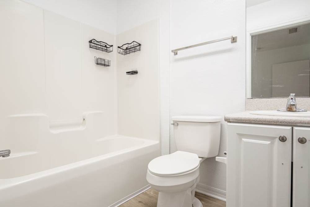 Bathroom with a toilet, large mirror and a bathtub at Cypress Commons in Wildwood, Florida