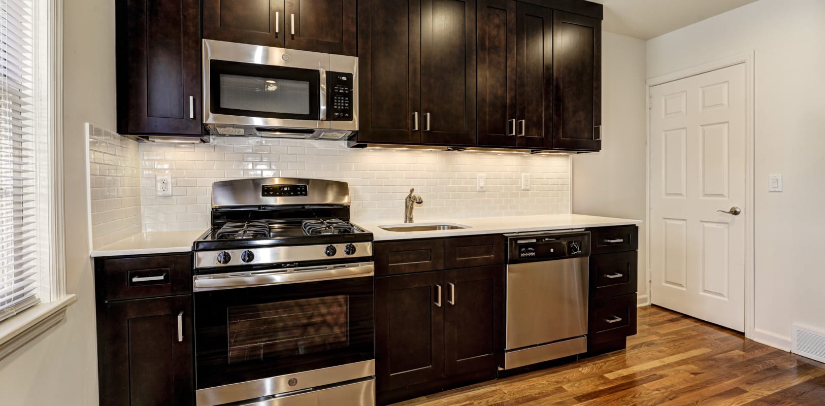 Spacious kitchen with stainless-steel appliances and wood-style flooring at General Wayne Townhomes and Ridgedale Gardens in Madison, New Jersey