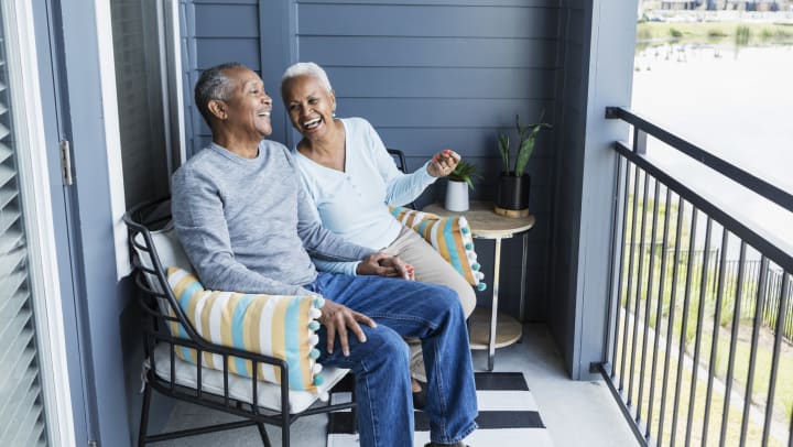 Senior couple laughing together on porch