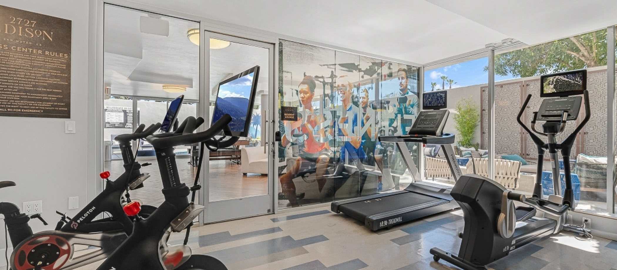A gym room with exercise equipment and a large window at 2727 Edison in San Mateo, California.