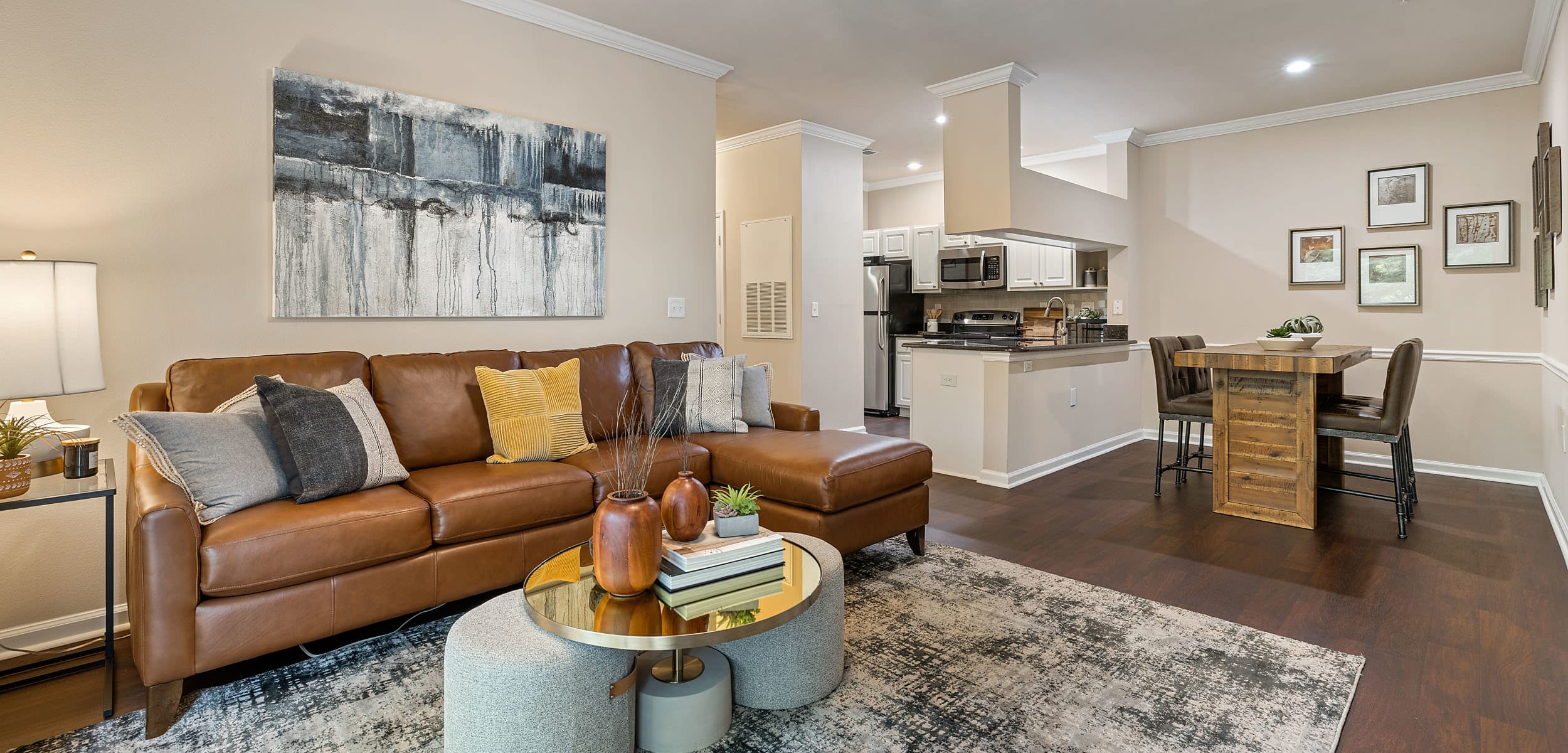 Spacious living area with modest dining area and wood flooring at Marquis at Carmel Commons in Charlotte, North Carolina