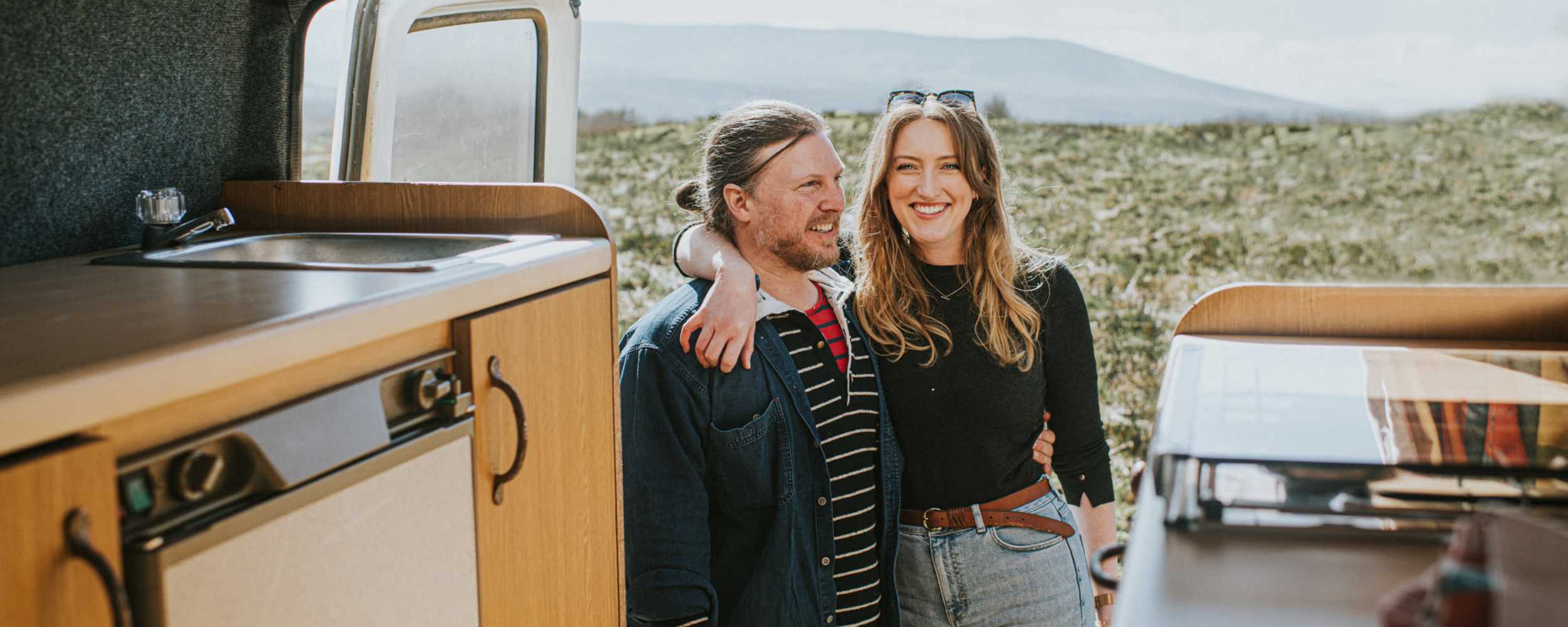 A couple stands together at the rear of a camper van at RoadRunner RV Storage, Roseville, California