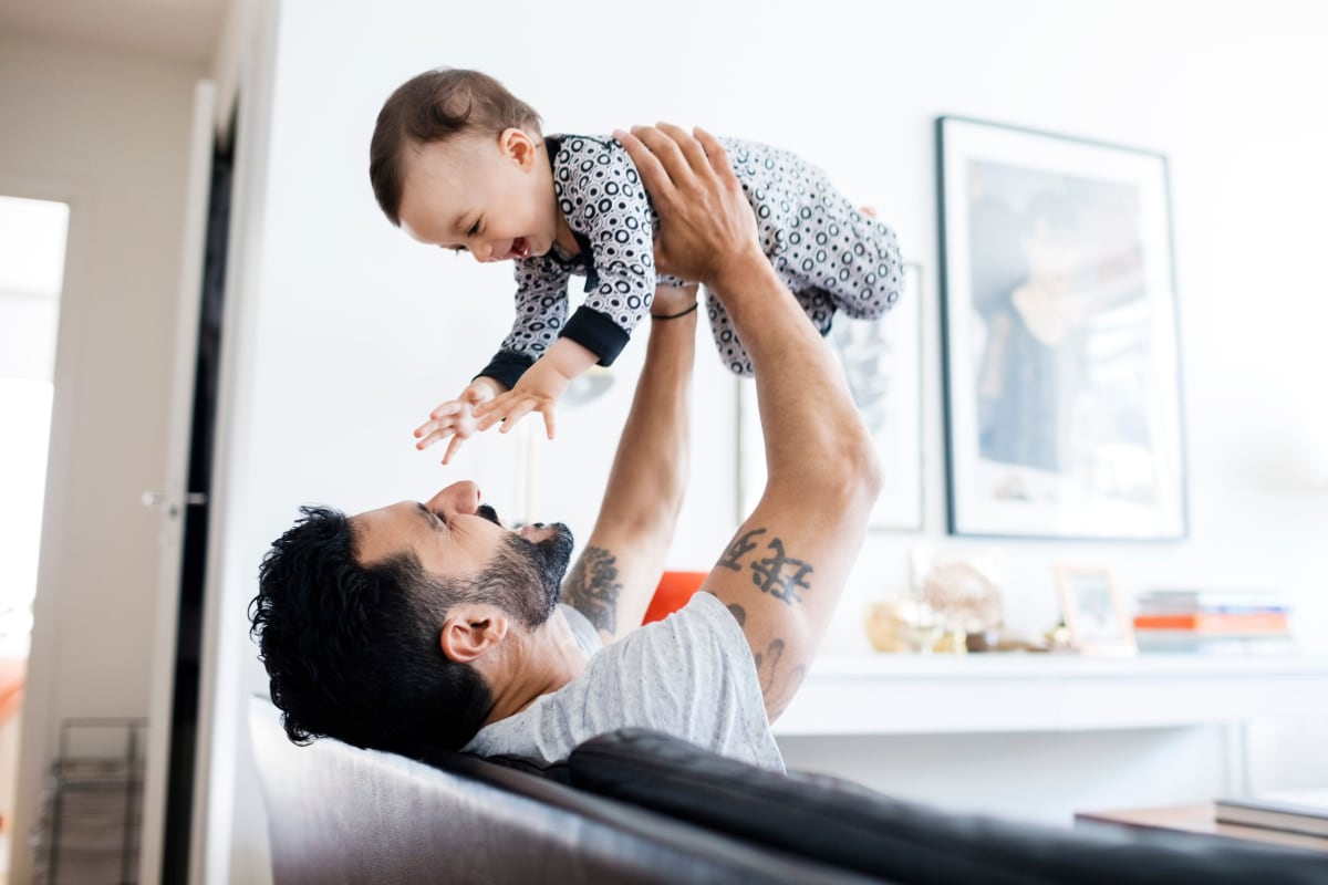 Father playing with his happy baby in their home at Mercury NoDa in Charlotte, North Carolina