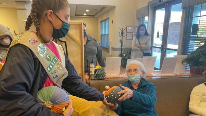 girl scouts gift pumpkins to residents of emerald place memory care