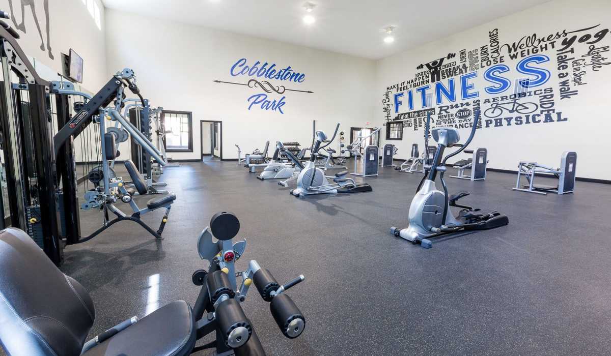 Fully equipped gym with treadmills, weight machines at Cobblestone Park in Manvel, Texas