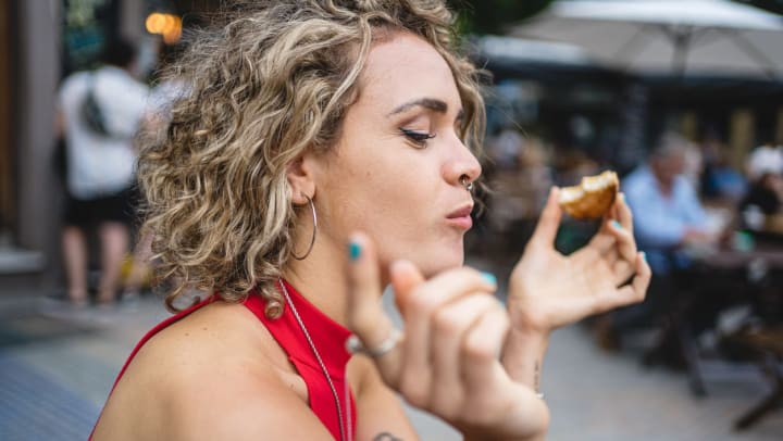 A woman eating a cookie at the Gilbert Farmers Market.