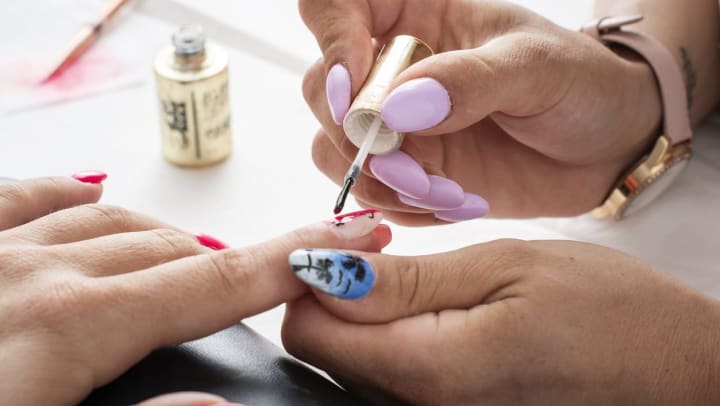 Manicurist painting a woman