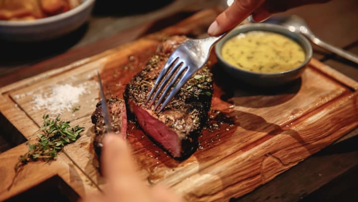 Person eating steak in a high-end restaurant | steakhouses near Pooler