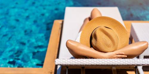Woman relaxing by the pool at Mountain Breeze Villas in San Bernardino, California