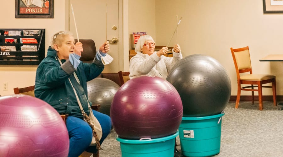 Memory care residents participating in a drumming activity at Cascade Park Gardens Memory Care in Tacoma, Washington