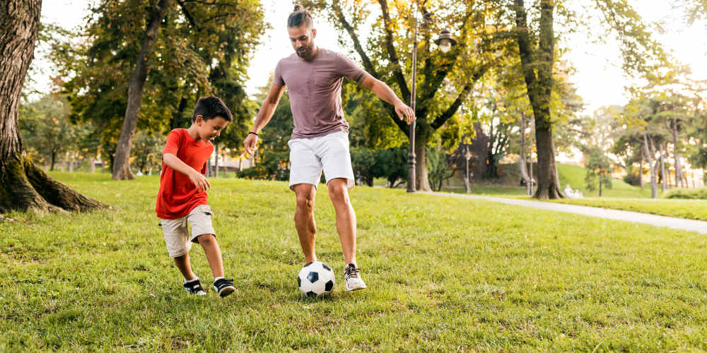 Father and son playing a football near Vesta Bouldercrest in Atlanta, Georgia