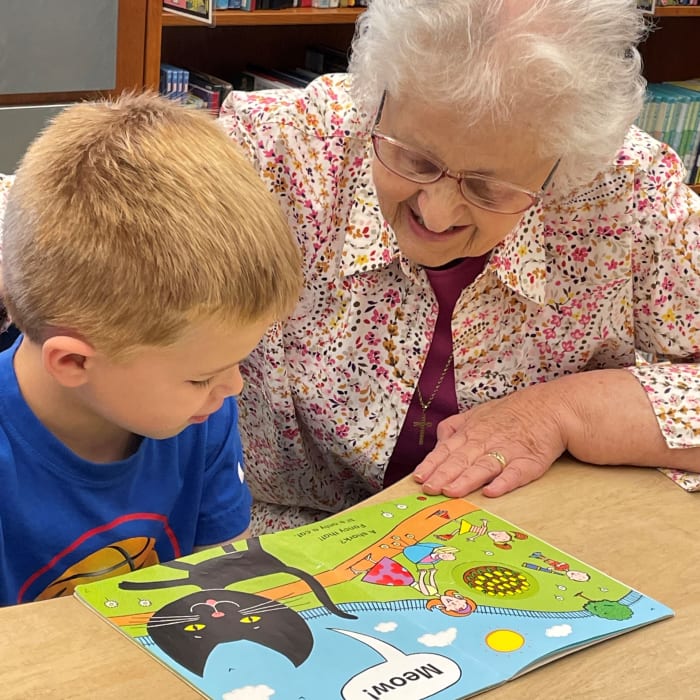 Resident helping a young boy read at Presbyterian Communities of South Carolina in Columbia, South Carolina
