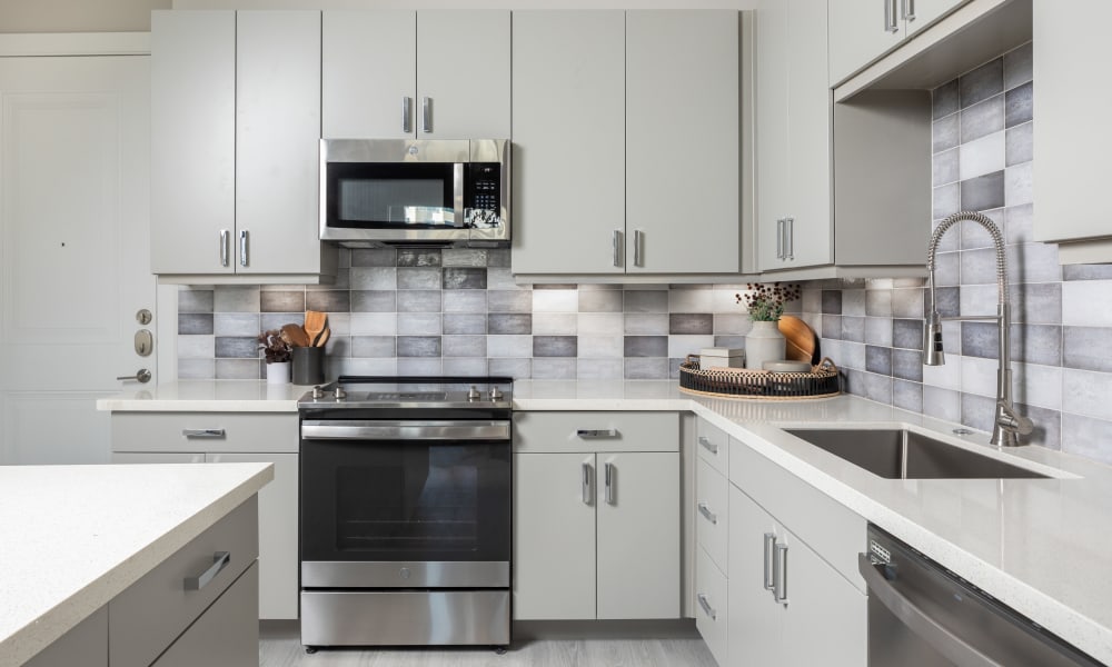 Apartment kitchen with white counters and cabinets at Bellrock La Frontera in Austin, Texas