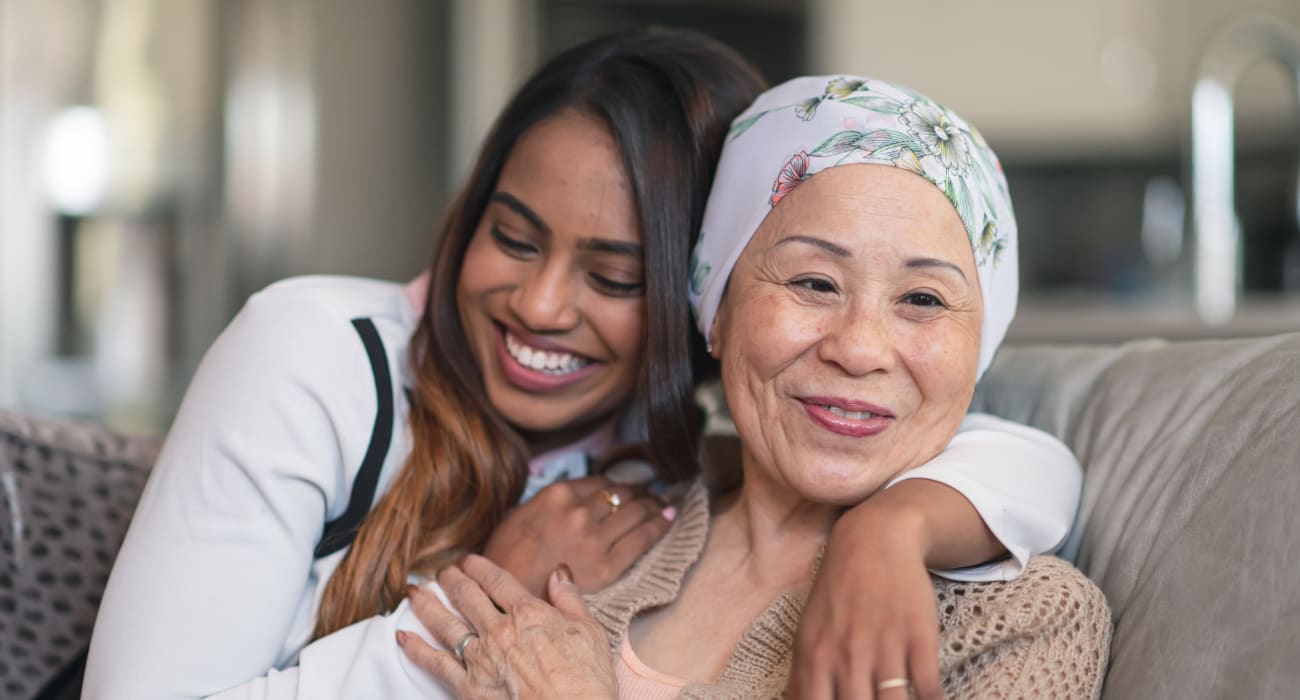 A resident and her friend smiling and hugging at Truewood by Merrill, River Park in Fort Worth, Texas.