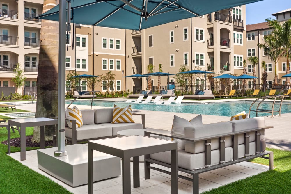 Outdoor lounge area at the pool at Murano at Three Oaks in Fort Myers, Florida