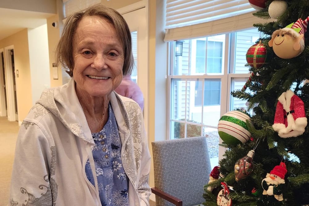 Smiling resident with a christmas tree at Legacy Living Green Township in Cincinnati, Ohio