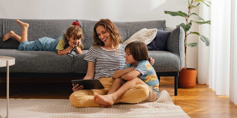 Resident woman with her kids in a living room at One Belmar Place in Lakewood, Colorado