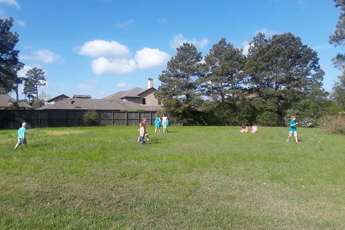 Apartment exterior with kids playing at Parsons House Cypress in Cypress, Texas
