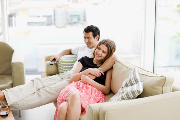 Couple sitting on the couch after getting all moved into their new place at Buffalo Run Apartments in Fort Collins, Colorado