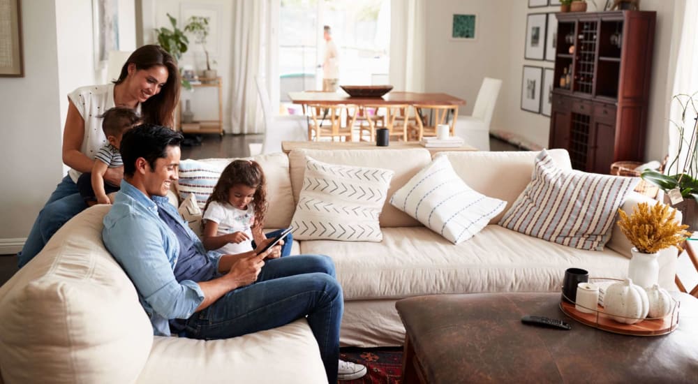 Resident family on the couch in a model home's living space at The Preston in Spring, Texas