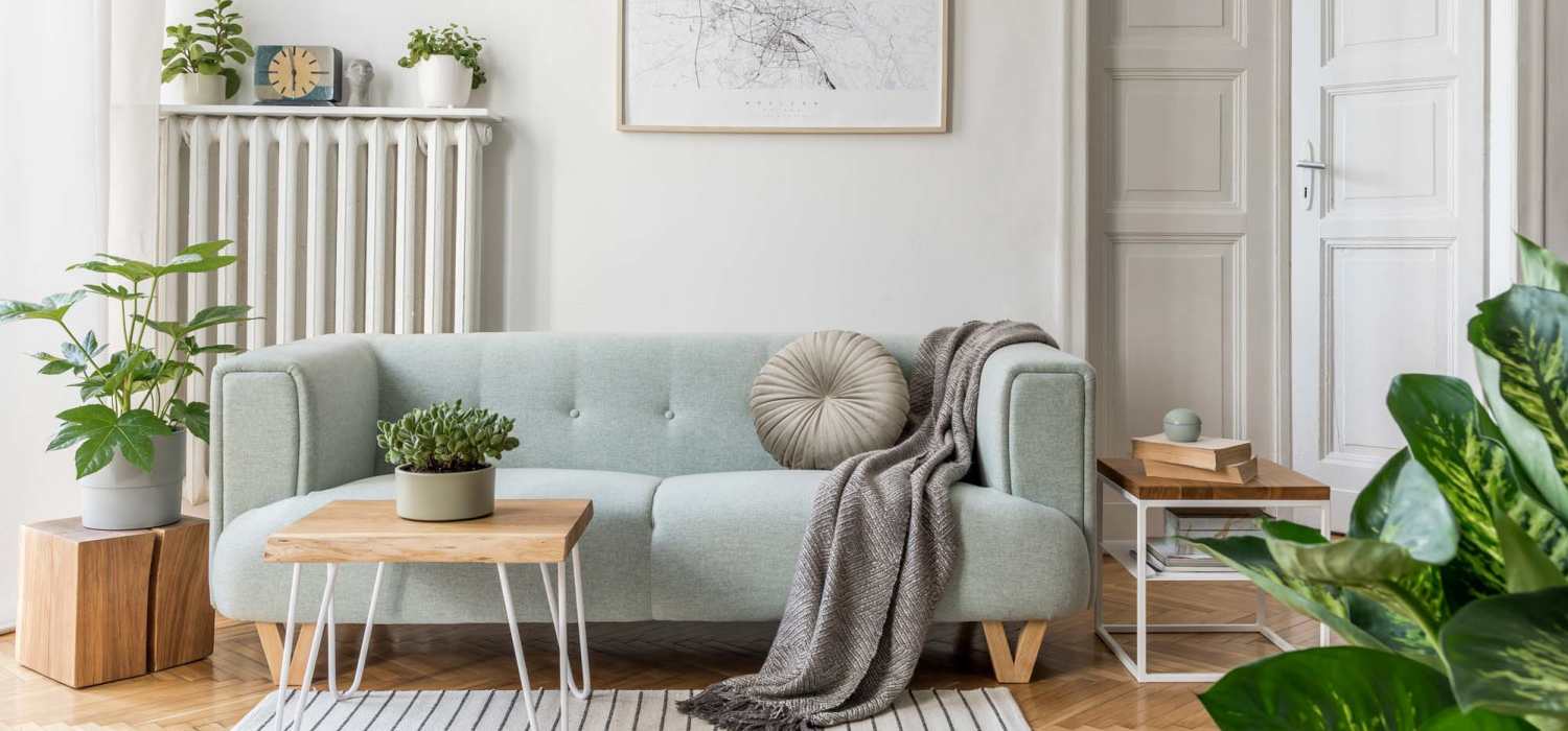 Open layout living room with couch and natural lights at Whispering Pines in Grayling, Michigan