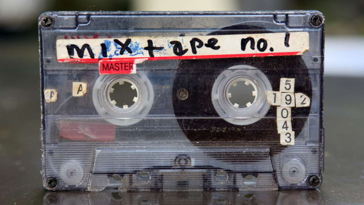 Audio cassette tape with a label on it that says “mixtape no. 1” in front of a blurred background.