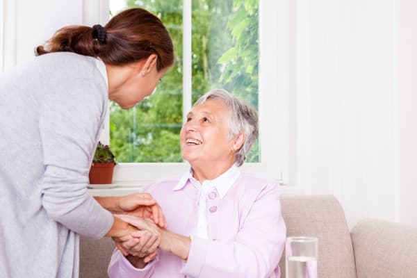 Senior woman laughing with elderly care nurse