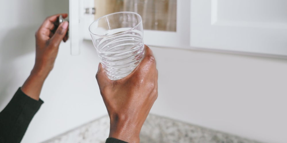 A resident taking a glass out of a cupboard at The Baldwin in Orlando, Florida